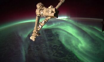 At the International Space Station, an astronaut captured an amazing green aurora behind a Soyuz spacecraft